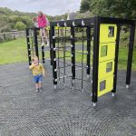 A group of children enjoying different parts of a playground structure