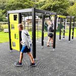 Children playing on a modern outdoor climbing frame in a park