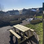 Timber picnic bench with surrounding landscaping