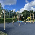 Overview of new playground with swing set and climbing frame