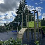 Play tower with slide and curved climbing ramp