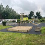 Play tower with slide and curved climbing ramp