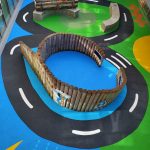 Role play area with wooden fencing surrounded by bold wetpour surfacing